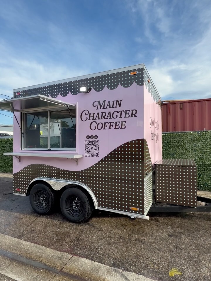 The Main Character Coffee trailer: pink and lavender body with a brown polka dot wave, scalloped trim, and the Main Character Coffee logo on the side